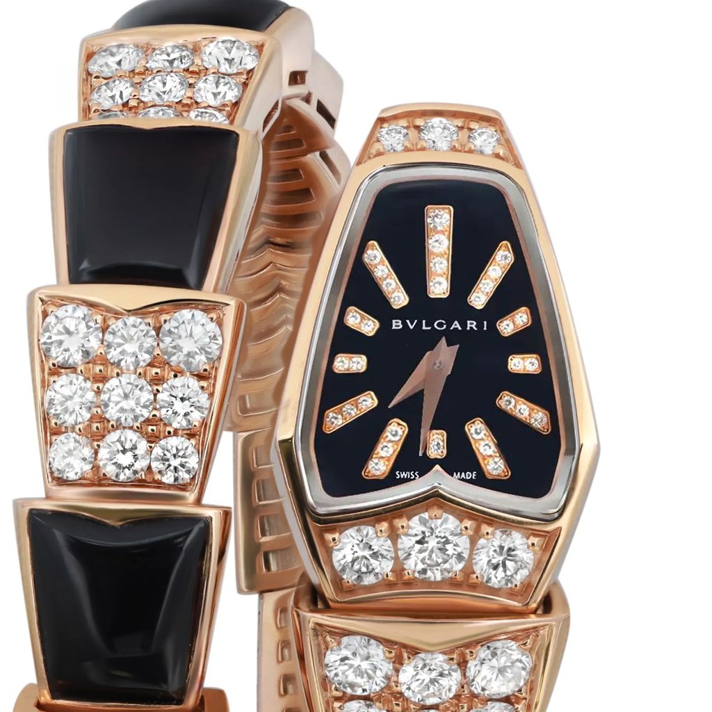 An image of a wristwatch taken from a front close-up angle, highlighting the watch face. The watch is pre-owned, featuring a black dial with gold-tone hour markers embellished with diamonds. The band is adorned with alternating sections of black enamel and diamond clusters, set in a gold-tone material. The brand name is visible on the watch face.