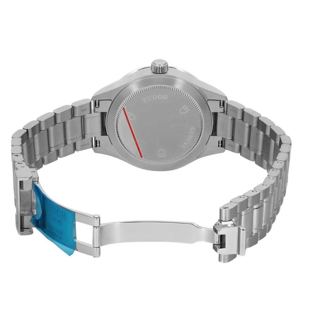 An image of a wristwatch from the back view, showcasing the open clasp. The watch is positioned at a slight angle, allowing a clear view of the stainless steel bracelet and the back of the watch case. The image is taken from a moderate distance, emphasizing the unworn condition of the wristwatch.