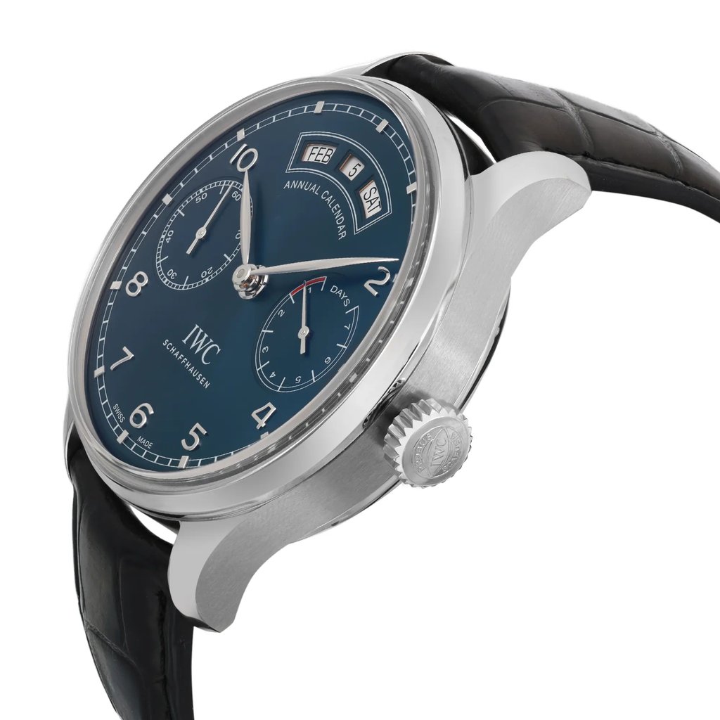 An image of a pre-owned wristwatch captured from a side profile view, highlighting the crown. The watch features a sleek silver case and a black leather strap. The dial is a deep blue with white numerals and includes subdials and a date window. The angle showcases the watch's elegant design, emphasizing its craftsmanship at a close distance.