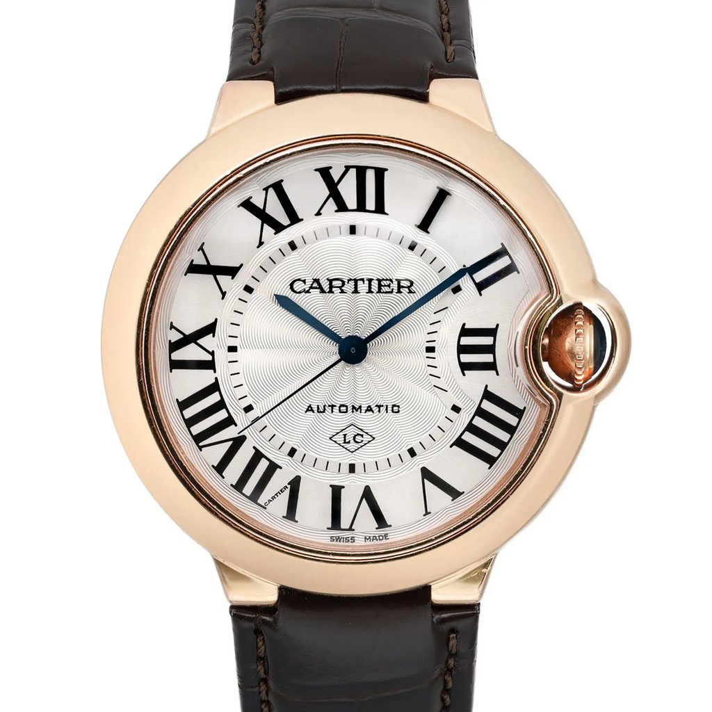 An image of a pre-owned wristwatch, featuring a close-up, front view of the watch face. The watch has a round case with Roman numeral hour markers and elegant blue hands. The case has a rose gold finish, and the strap is made of dark brown leather. The image highlights the intricate details of the watch face at a close distance.