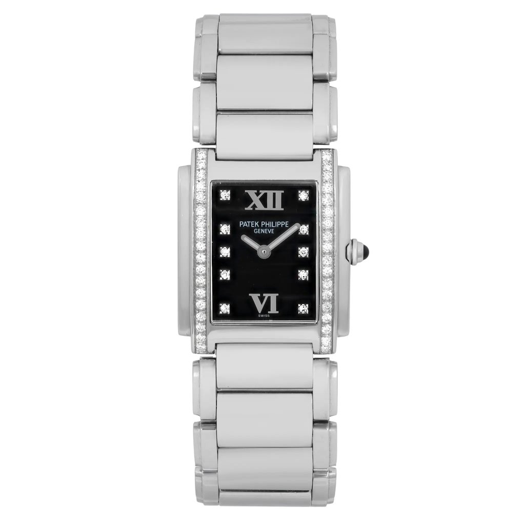 An image of a pre-owned Patek Philippe women's Twenty4 Steel Quartz 0.45ct Diamond Black Dial wristwatch taken from a front-facing angle at a close distance. The watch features a rectangular black dial with luminous hands and Roman numerals at the 12 and 6 positions. The bezel is adorned with diamonds, and the watch has a stainless steel bracelet with a polished finish.