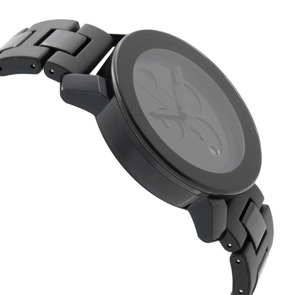 An image of a pre-owned wristwatch captured from a side profile view, opposite the crown. The watch has a sleek, dark design with a metal link band. It is positioned at a slight angle, highlighting its thickness and detailing, with the face of the watch visible from a close distance.
