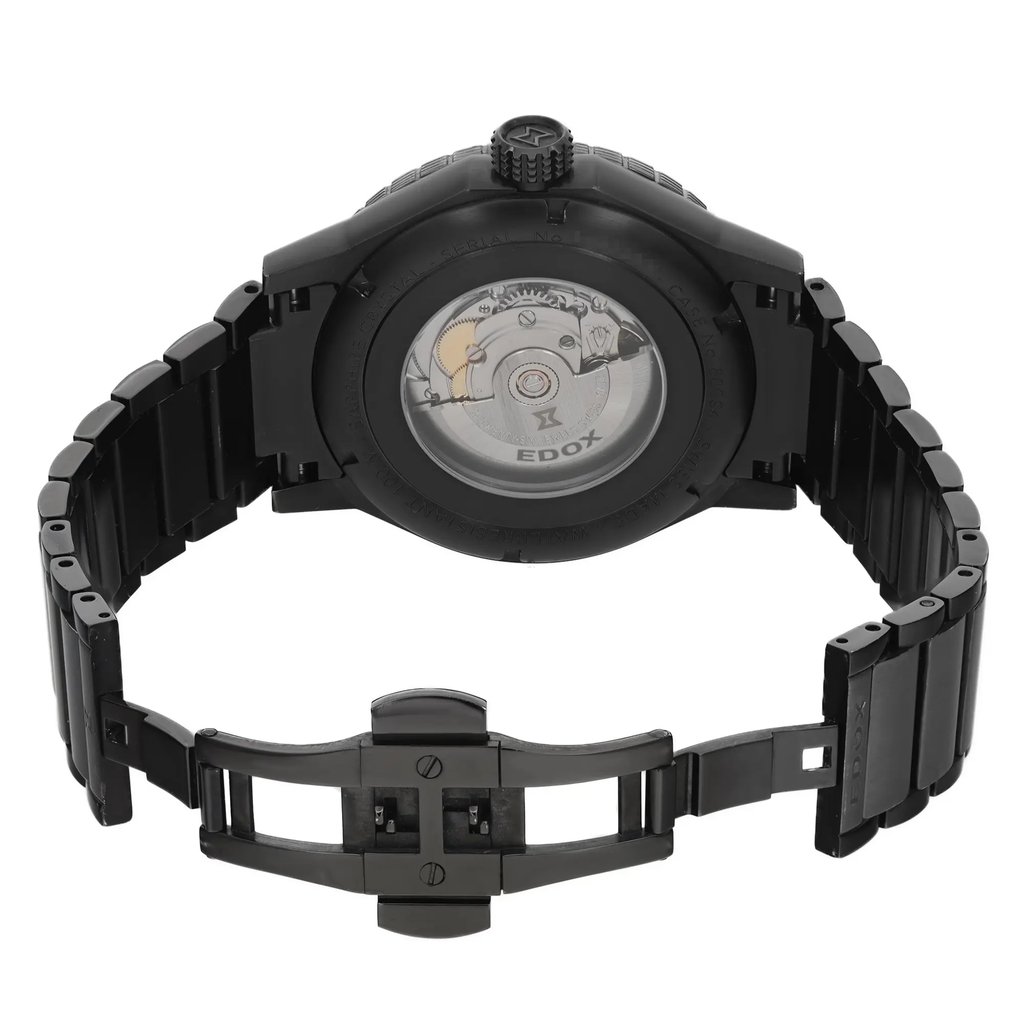 An image of a pre-owned wristwatch viewed from the back. The watch has an open clasp, and the angle captures the intricate mechanical details through the transparent case back. The watch is positioned upright, with the camera focused at a close distance, highlighting the black metal bracelet and clasp. The branding and mechanical components are clearly visible.
