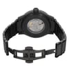 An image of a pre-owned wristwatch viewed from the back. The watch has an open clasp, and the angle captures the intricate mechanical details through the transparent case back. The watch is positioned upright, with the camera focused at a close distance, highlighting the black metal bracelet and clasp. The branding and mechanical components are clearly visible.