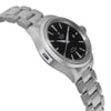 An image of a wristwatch taken from a side profile view, opposite the crown. The watch is unworn and features a metallic bracelet and a sleek black dial. The angle highlights the thickness of the watch case and the polished links of the bracelet. The photograph is taken at a moderate distance, capturing the elegance and detail of the timepiece.