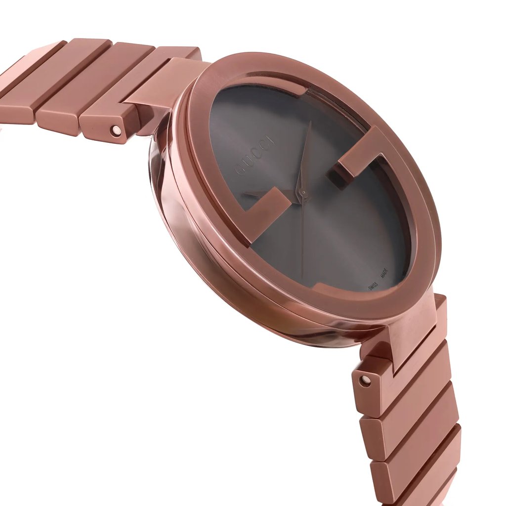 An image of a Gucci men's wristwatch in display model condition, shown in a side profile view opposite the crown. The watch features a casual style with a round shape, brown dial, and matching brown bezel. The band and case are made of stainless steel, and the watch appears to be photographed at a close distance, emphasizing the design details and brand name on the dial.