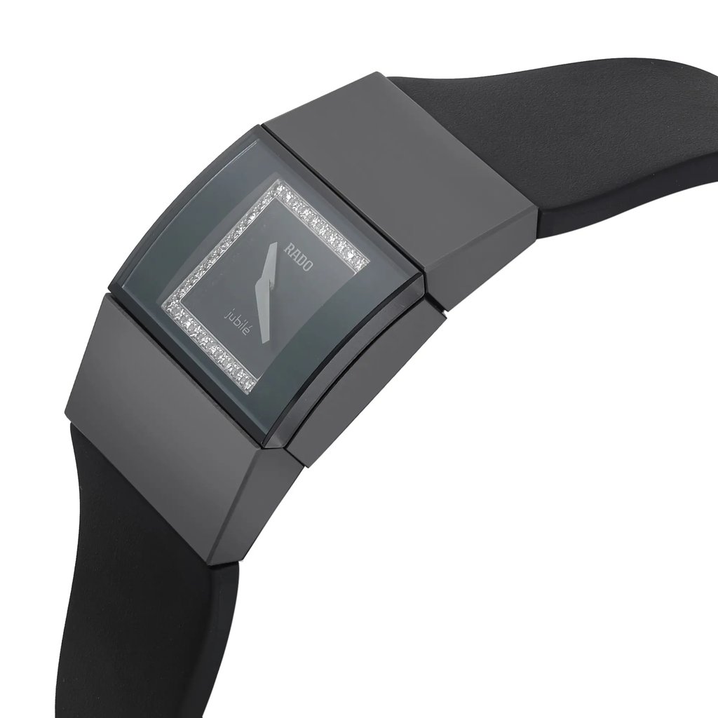 An image of a new with defects Rado women's wristwatch in a casual style, captured from a side profile view with the crown visible. The watch has a rectangle shape with a black ceramic case and a black rubber band. The dial is black with a diamond pattern and the bezel is also black. There are micro scratches on the case due to store handling, and the watch appears to be at a close distance, providing a clear view of the design details.