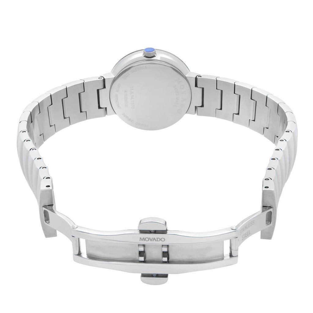 An image of a wristwatch taken from the back view, showcasing the open clasp. The watch is positioned centrally, with the bracelet extended to either side. The stainless steel links are clearly visible, and the brand name "Movado" is engraved on the clasp. The image is captured at a close range, highlighting the details of the display model.
