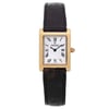 An image of a pre-owned wristwatch taken from a front full frontal view. The watch features a rectangular gold case with a white dial and Roman numeral hour markers. The brand name is visible on the dial. It has a black leather strap with a textured pattern. The image is captured at a close distance, highlighting the details of the watch's face and strap.