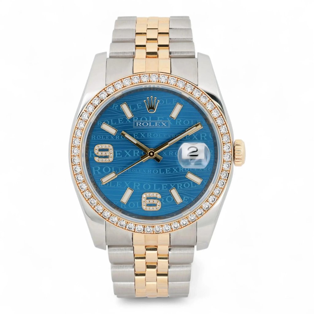 An image of a pre-owned unisex Rolex Datejust 36 18k Gold Steel Diamond Blue Wave Dial Watch 116243 taken from a front angle at a close distance. The watch features a two-tone metal bracelet with gold and steel links. Its bezel is adorned with diamonds, and the blue dial displays a date indicator at the 3 o'clock position. The hour markers and hands are gold-toned, complementing the overall luxurious design.