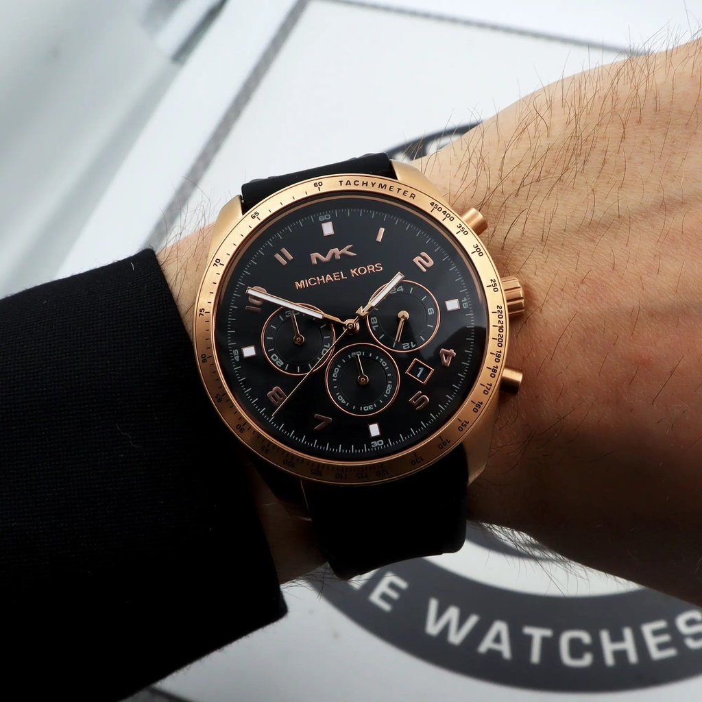 An image of a Wristwatch by Michael Kors. This Display Model item is designed for Men, featuring a Dress/Formal style. It has a Quartz movement and an Analog display with a Black dial color. The indices include 12-Hour Dial,Arabic Numerals. The band is made of Silicone and the case is made of Stainless Steel. The watch has a Round shape with a case size of 42 mm and a case thickness of 11 mm.
