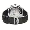 An image of an unworn IWC men's wristwatch with a stainless steel case and an exhibition caseback, viewed from the back at a slight angle. The round watch is attached to a black leather band with a deployant closure, and the clasp is prominently displayed in the foreground. The photo is taken up close, capturing the intricate details and textures of the watch's design.