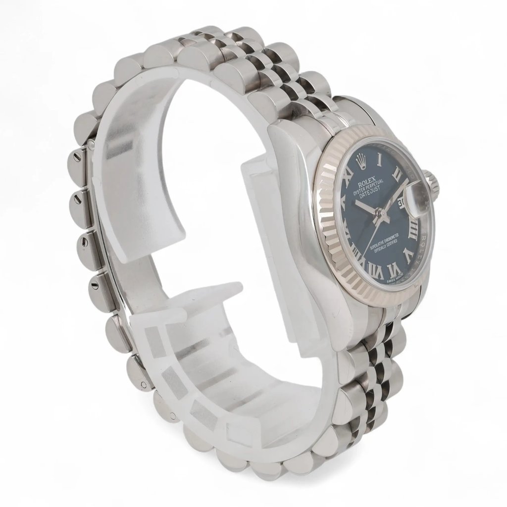 An image of a pre-owned women's Rolex wristwatch, positioned at a three-quarter angle, highlighting its silver bracelet and dark watch face with luminous hands. The watch is viewed from a close-up distance, showcasing its intricate details, including the fluted bezel and Roman numerals.