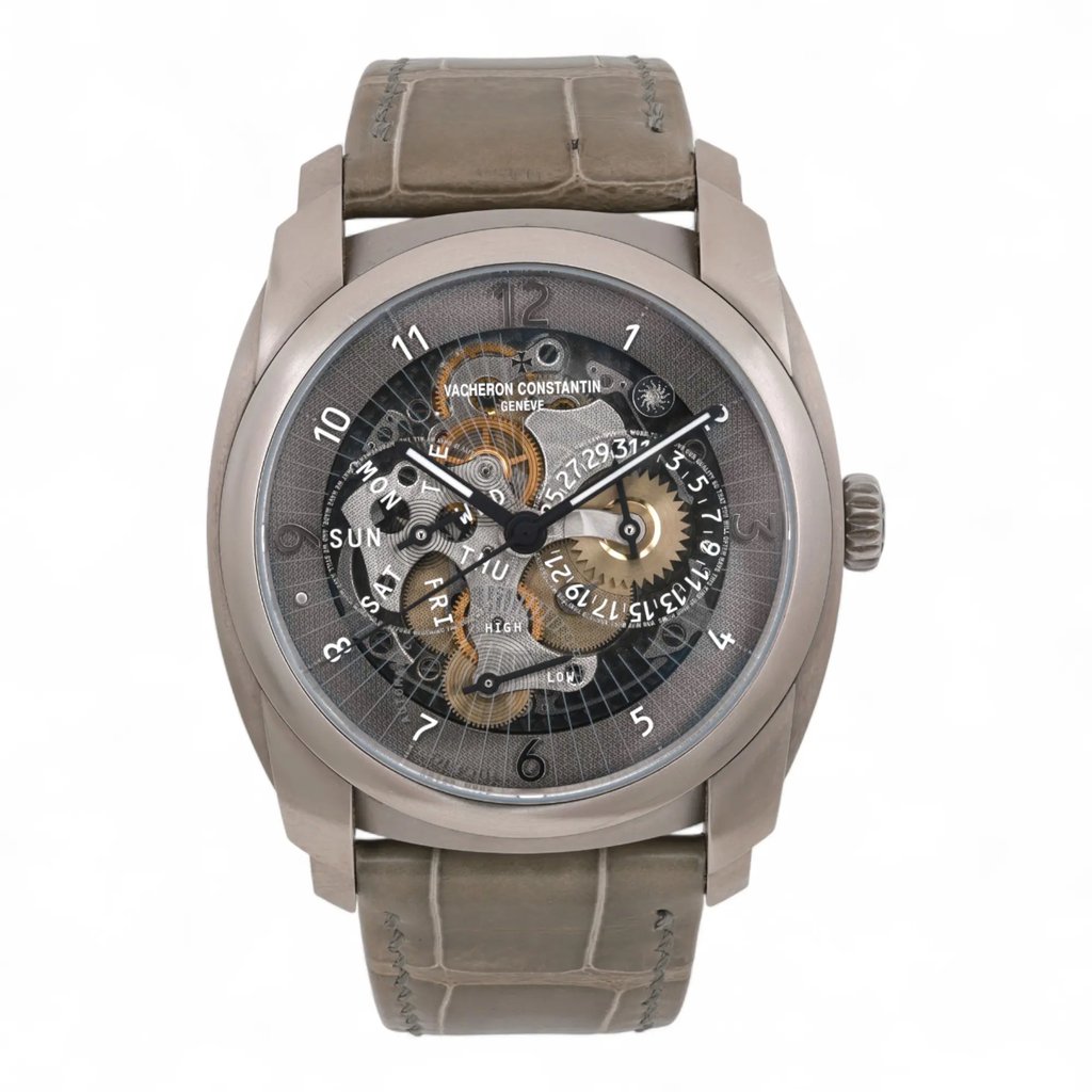 An image of a pre-owned Vacheron Constantin Quai de l'Ile Titanium men's wristwatch, viewed from the front at a close distance. The watch has a detailed dial featuring luminous hands, multiple sub-dials, and visible mechanical components. The case is metallic with a textured, light brown leather strap. Comes with a Vacheron Passport. Unworn Band. No original box. Recently serviced. The movement is calibrated and keeps time well.

