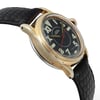 An image of a pre-owned women's Rolex wristwatch positioned at a slight angle from the left side, showcasing the watch face and part of the band. The watch has a gold-toned case and a black leather strap with a textured pattern. The dial is black with large contrasting numerals and a red second hand. The shot is taken at a close distance, emphasizing the details of the watch's design and condition.
