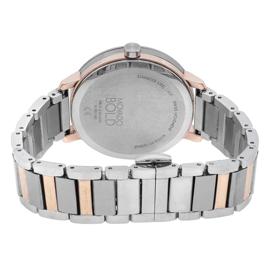 An image of a pre-owned wristwatch, viewed from the back, showcasing the closed clasp. The angle captures the stainless steel case and the branding engraved on the back. The watch features a metal bracelet with alternating silver and rose gold links. The shot is taken from a close distance, highlighting the details and condition of the watch.