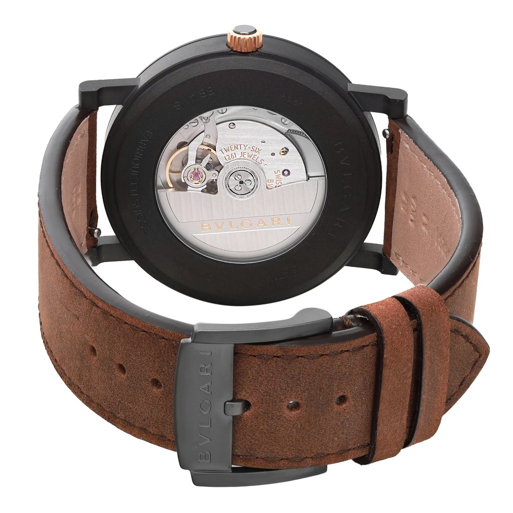 An image of an unworn Bvlgari men's wristwatch with a close-up back view showcasing the exhibition caseback. The stainless steel case has a round watch shape and is attached to a brown leather band. The band's buckle closure is visible and securely fastened. The watch is positioned at a slight angle with the top tilting away from the viewer, providing a clear view of the mechanical components and branding through the caseback. The image is taken from a close, but not macro distance, ensuring the entire back side of the watch is visible.