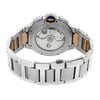 An image of a pre-owned Cartier men's wristwatch, displayed from the back view, showcasing the exhibition caseback and closed double-locking fold-over clasp. The watch is positioned centrally and shot from above at a close distance, allowing clear visibility of the stainless steel case material intermixed with solid gold elements on the band. The round shape of the watch is evident, with a notable blue cabochon on the crown visible from this angle.
