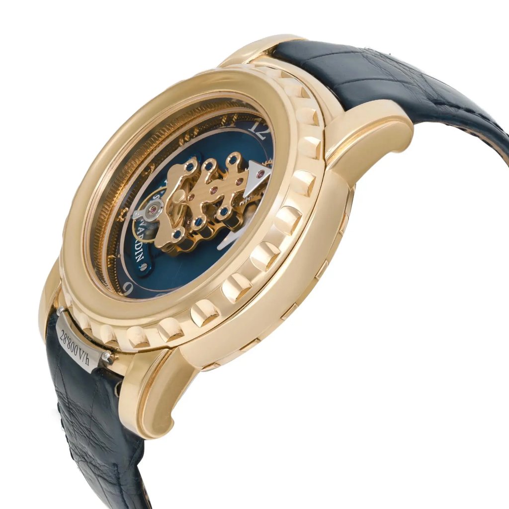 An image of a pre-owned wristwatch taken from a side profile view. The watch features a gold-toned case with a visible crown. The detailed mechanical parts are visible through the blue dial. The strap is black with a textured pattern, and the image captures the watch at a close angle, highlighting its intricate design and craftsmanship.