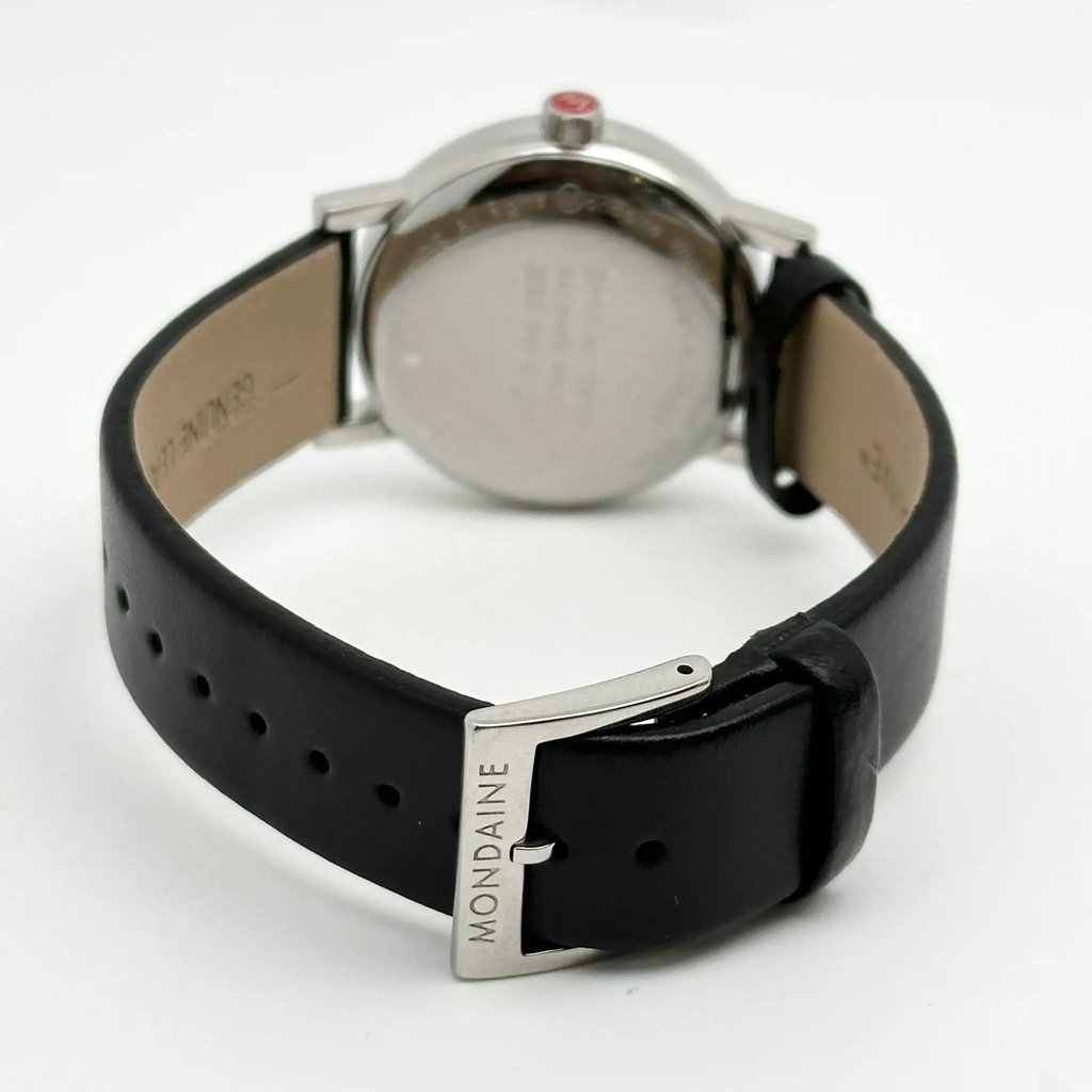 An image of a Wristwatch by Mondaine. This Display Model item is designed for Men, featuring a Classic,Dress/Formal style. It has a Quartz movement and an Analog display with a White dial color. The indices include 12-Hour Dial,Non-Numeric Hour Marks,Stick Indexes. The band is made of Leather and the case is made of Stainless Steel. The watch has a Round shape with a case size of 35 mm and a case thickness of 9 mm.