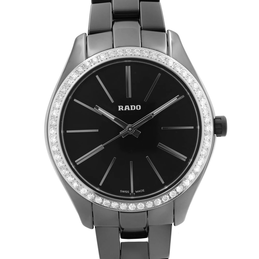 An image of a wristwatch taken from a front close-up angle, showcasing the watch face prominently. The watch features a sleek black dial with minimalistic hour markers and hands. The bezel is adorned with a row of sparkling stones, adding an elegant touch. The condition of the watch is noted as a display model, and it is attached to a polished metal bracelet.