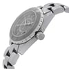 An image of a pre-owned wristwatch captured from a side profile view, highlighting the crown prominently. The watch features a metallic band and a round face with visible numbers. The angle showcases the watch at a slight tilt, emphasizing its sleek design and craftsmanship.