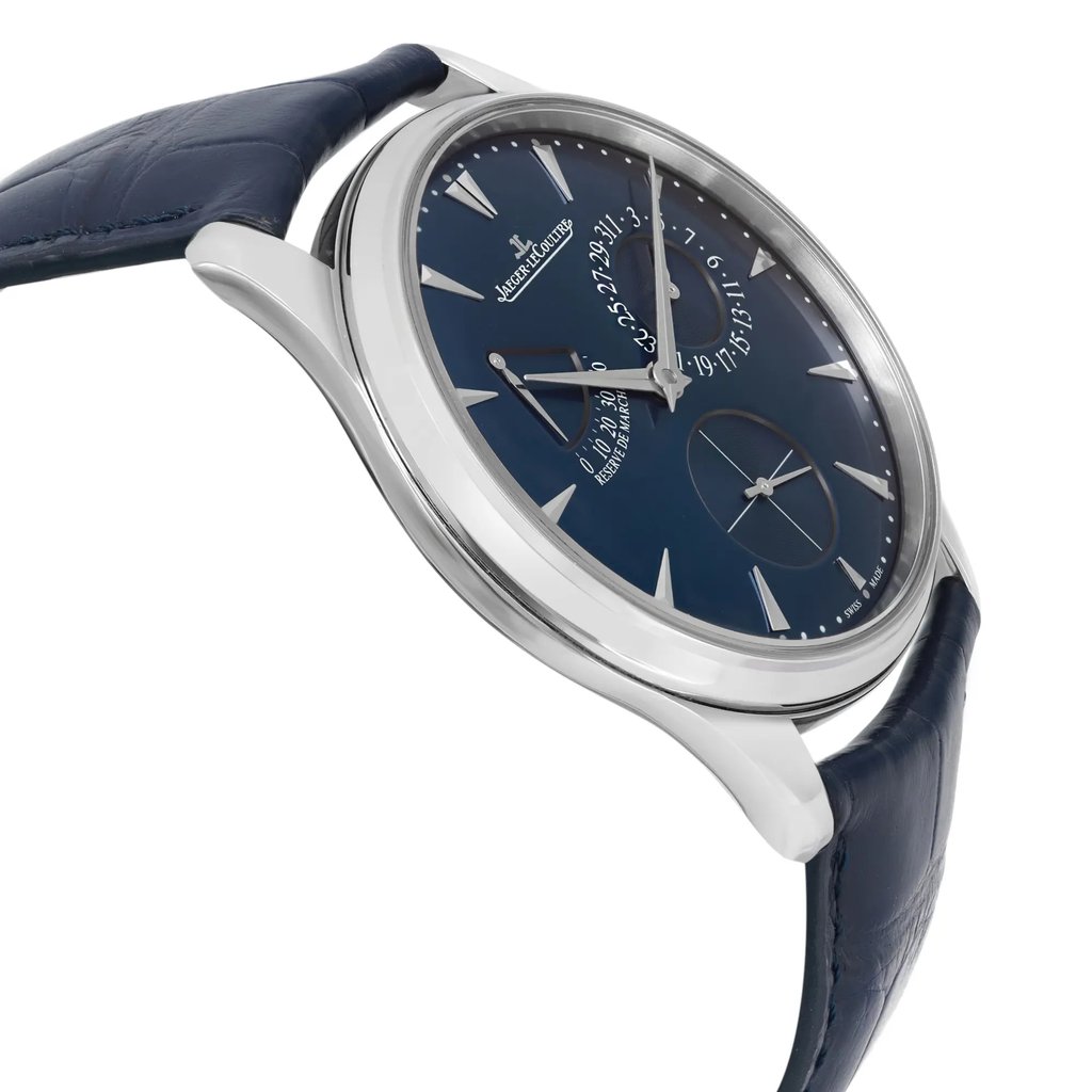 An image of a pre-owned wristwatch captured from a side profile view, opposite the crown. The watch features a sleek design with a dark blue dial and matching leather strap. The angle highlights the watch's silver case and the details on its face, including indices and subdials, creating an elegant appearance. The photograph is taken at a close distance, emphasizing the watch's craftsmanship and condition.