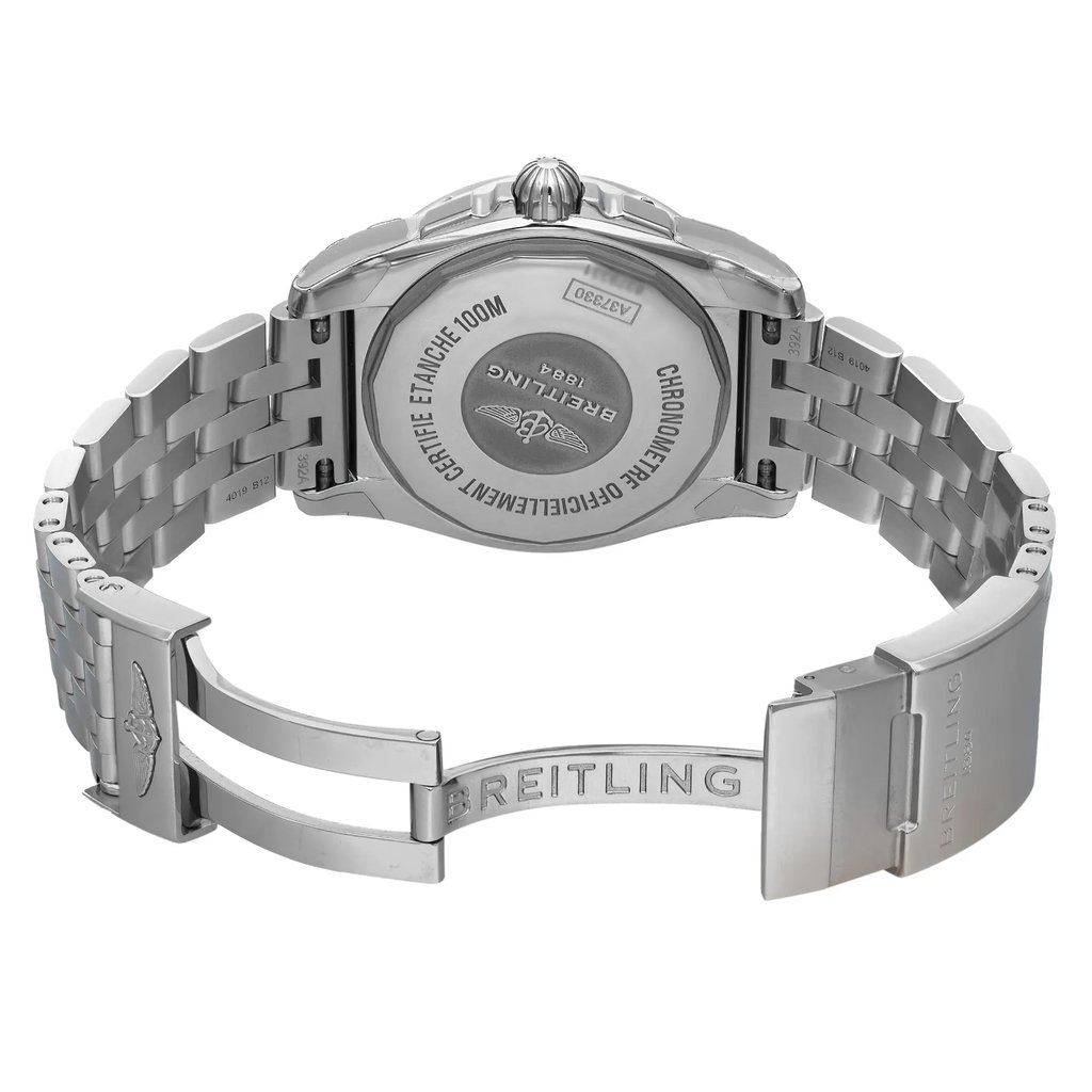An image of an unworn Breitling women's wristwatch, viewed from the back. The round stainless steel caseback features engraved text and the brand's logo, and it is attached to a stainless steel band with a fold-over clasp open to reveal the flip lock safety mechanism. The watch is positioned at a slight angle to the camera, providing a clear view of the screwback case and the interior side of the clasp, which also displays the Breitling name. The watch appears to be at a close distance, allowing for detailed inspection of its features. The watch show minor blemishes due to store handling.