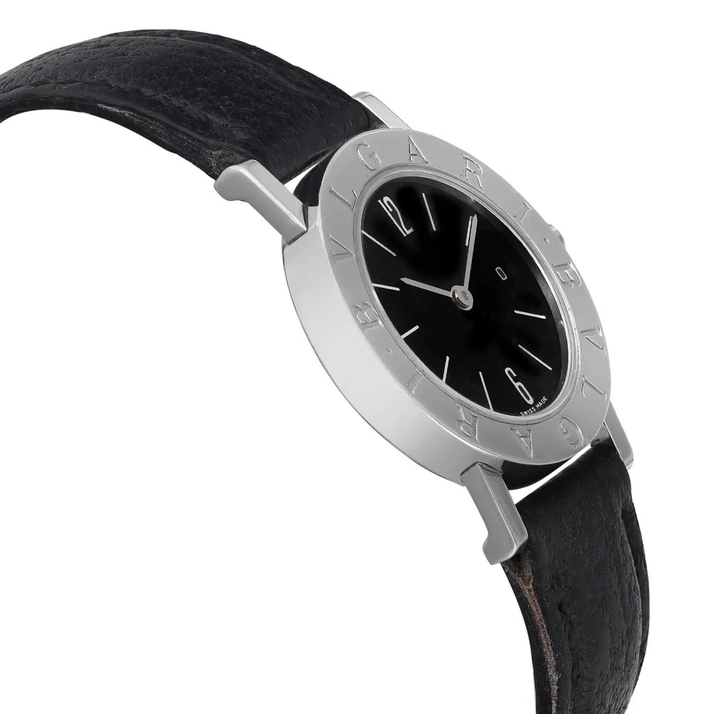 An image of a pre-owned Bvlgari women's wristwatch, featuring a date indicator. The watch is positioned at a slight angle, showcasing the round black dial and steel bezel engraved with "Bvlgari." The black leather strap is visible, with the watch photographed from a close distance, emphasizing its sleek design and detailing.