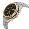 An image of a pre-owned Omega men's wristwatch taken from a side profile view, showcasing the crown. The watch has a round shape with a stainless steel case and band. The black dial features a chronograph, date indicator, luminous hands, and a small seconds subdial. The gold bezel contrasts elegantly with the stainless steel band, highlighting the casual style of the timepiece. The watch is in good condition, and the angle emphasizes its detailed craftsmanship.