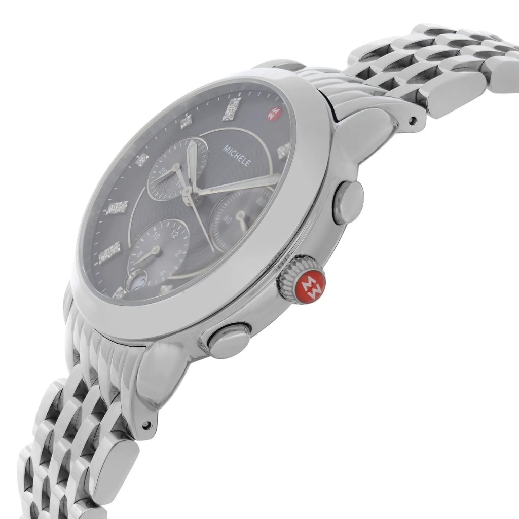 An image of a wristwatch shown from a side profile view, highlighting the crown. The watch is positioned at an angle that showcases its metallic bracelet and detailed face, with a focus on the crown featuring a red accent. The distance is close enough to capture the intricate design elements of the display model.