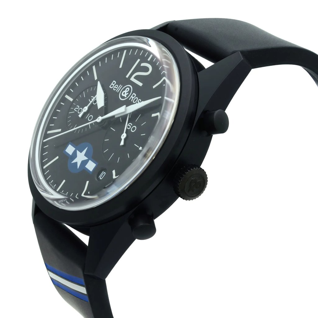 An image of a wristwatch positioned at a 45-degree angle, with the face of the watch prominently displayed. The watch has a black strap with blue accents, a black casing, and a crown on the right side. The dial is black with white numerals and hands, and features the Bell & Ross logo. The image is a close-up, showing the watch in detail against a white background. Watch is in unworn condition. 