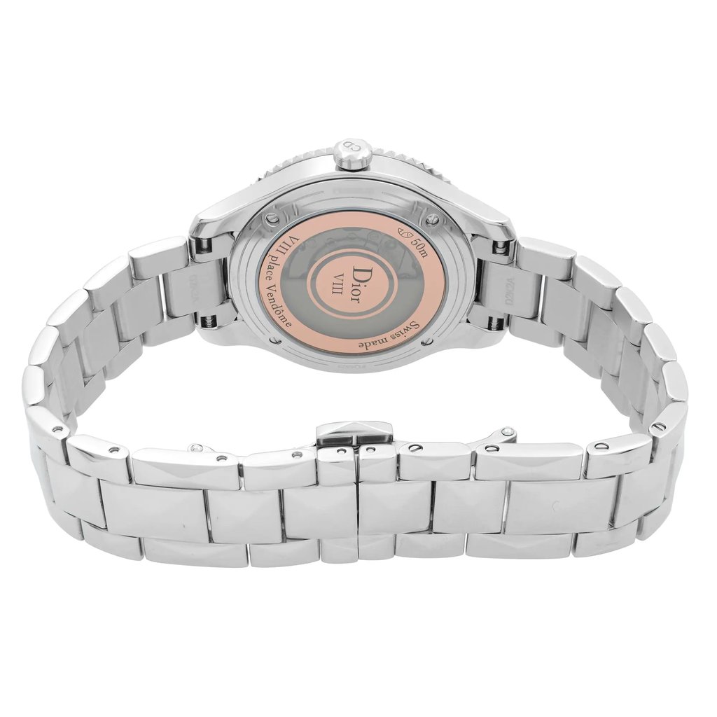 An image of a women's Dior wristwatch viewed from the back, showcasing a close clasp. The watch has a round shape with a stainless steel case and band. The exhibition caseback is visible, highlighting the Dior branding. The watch is positioned horizontally, angled slightly to display the clasp, and photographed from a close distance. The condition is excellent, indicative of a display model.