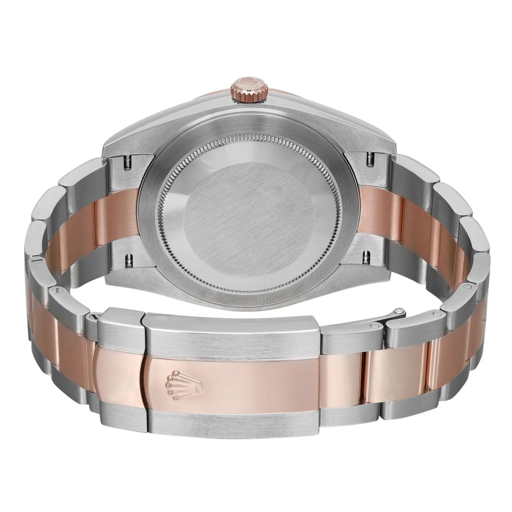 An image of an unworn Rolex men's wristwatch, shown from the back view with a close clasp. The watch has a round case made of stainless steel with a screwback caseback. The band is composed of alternating stainless steel and rose gold links, featuring a fold-over clasp. The perspective is a close-up, focusing on the clasp area with the rest of the watch slightly out of focus, angled to display the design and materials of the band and the backside of the watch case.