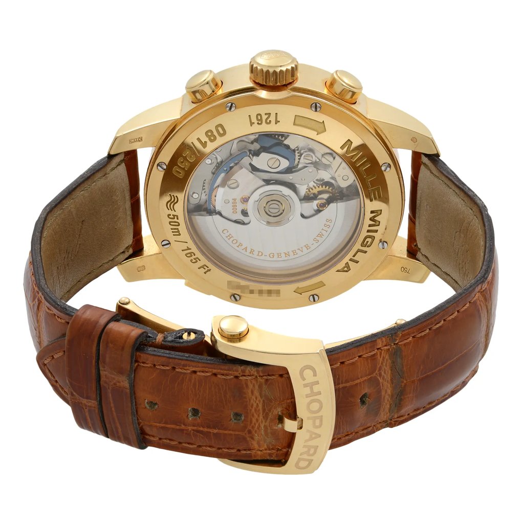 An image of a pre-owned men's Chopard wristwatch viewed from the back at a close angle. The watch features a gold case with visible chronograph buttons and a transparent back showcasing the intricate mechanical movement. The brown leather strap is partially visible, and the Chopard branding is engraved on the clasp.