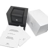 An image of an unworn IWC men's wristwatch box and documents, presented without the watch itself. The box, positioned in the center, is open, showcasing a black leather cushion intended for the watch. To the right, there's a white outer box with the IWC logo. In the foreground and various documents.