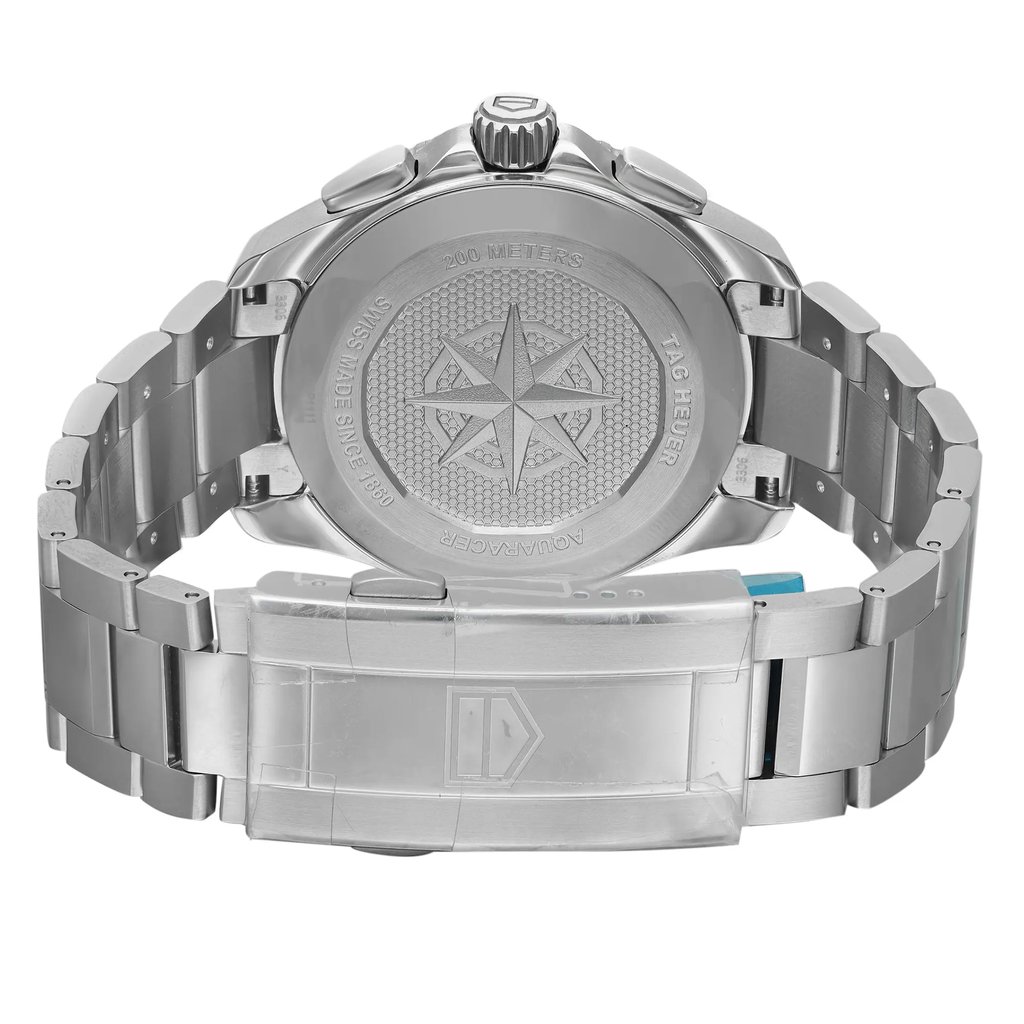 An image of an unworn TAG Heuer men's wristwatch viewed from the back. The screwback case is made of stainless steel and features an engraved star pattern. The round watch case is connected to a stainless steel band that utilizes a fold-over clasp with double push buttons, which is shown in the closed position. A protective sticker is visible on the clasp. The watch is positioned at a slight angle, with the back facing upwards and the band partially visible, The image is shot at a close distance, providing a clear view of the watch's details.