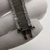 An image of a pre-owned Tissot women's wristwatch, focusing on the mesh band which shows signs of damage. The close-up shot is taken from a top-down angle, highlighting the watch's clasp area and part of the band. The band features rows of clear diamonds set along the edges indicating wear. The woven texture of the mesh band is visible, and the metallic elements have white-gold finish. The watch is displayed against a soft, textured backdrop, and is held by a hand wearing a white glove, suggesting careful handling.