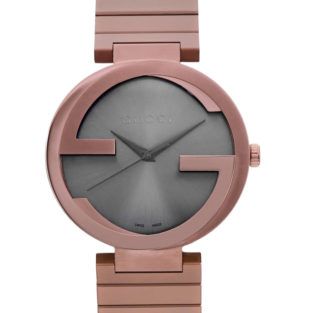 An image of a men's Gucci wristwatch, presented as a display model in excellent condition. This close-up view captures the front angle of the watch face, focusing on the round, brown dial with a matching brown bezel. The stainless steel band is visible, extending toward the bottom of the frame, suggesting a casual style. The watch hands are positioned near the center of the dial, which features the Gucci logo but no hour marks, and the image is taken from a close, direct front perspective.