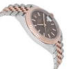 An image of a pre-owned men's Rolex Datejust 41mm wristwatch viewed from a slight side angle. The watch features a two-tone stainless steel strap with rose gold links. The face is dark with luminous hands and a date indicator. The bezel is fluted, adding a textured appearance. The angle highlights the watch's thickness and intricate details of the bracelet, taken from a close to medium distance.
