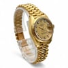 An image of a pre-owned women's Rolex wristwatch, positioned at a slight angle to showcase its design. The watch features an  18k yellow gold bracelet and case with a date indicator on the dial. Diamond hour markers adorn the face, adding elegance. The photograph is taken from a close distance, highlighting the watch's intricate details and craftsmanship.