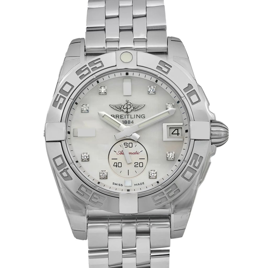 An image of an unworn Breitling women's wristwatch in excellent condition, viewed from the front in a close-up shot, showcasing the entire watch face and part of the stainless steel band. The round case has the original protective sticker, and the watch features a luxurious white mother of pearl dial with gray bezel, diamond markers on the 12-hour dial, a date indicator at the 3 o'clock position, and luminous hands. The Breitling logo and name are prominently displayed below the 12 o'clock position. The stainless steel band and case give the watch a cohesive and elegant appearance.