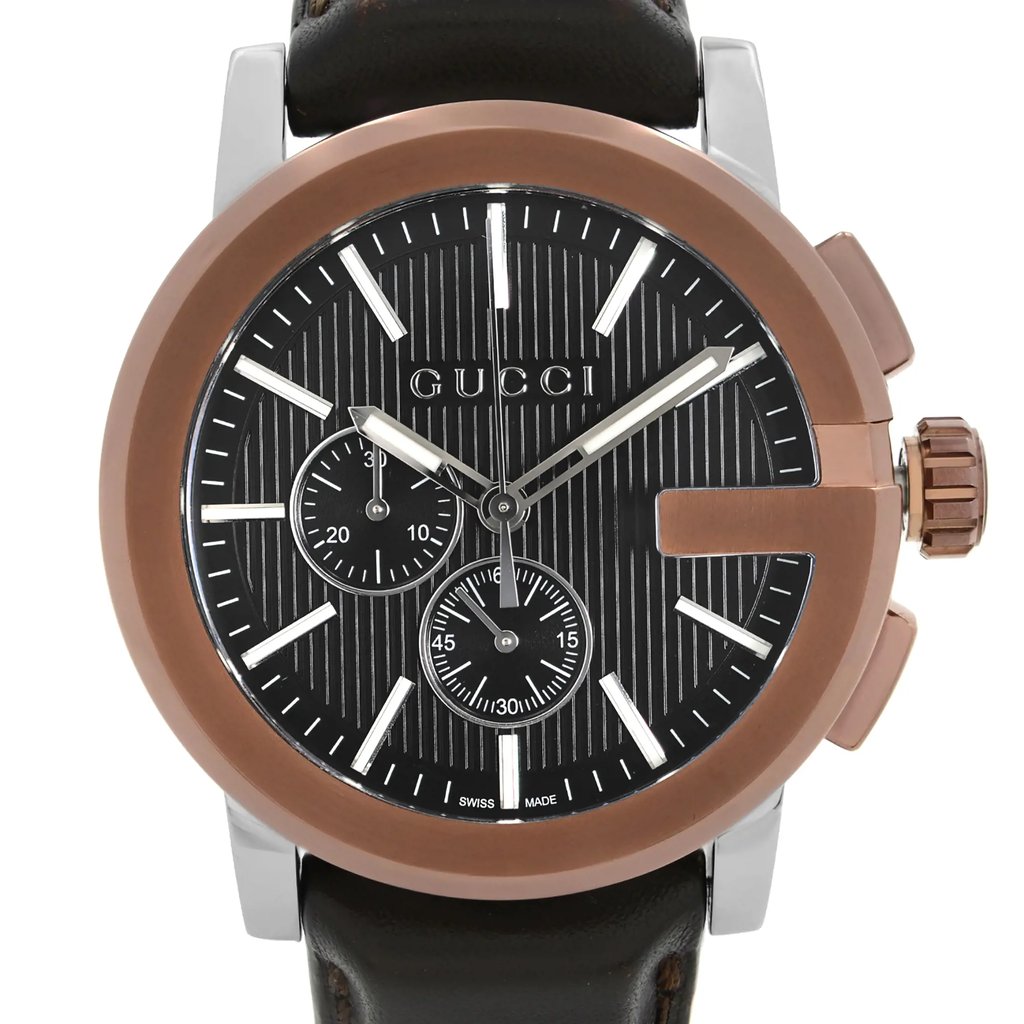 An image of a pre-owned Gucci men's wristwatch in good condition. The photograph is a front close-up shot of the watch face, highlighting its round shape, black teaked dial, and bronze bezel. The watch features stick indexes and non-numeric hour marks for the 12-hour dial, with additional multi-dial functions. It includes a chronograph and a small seconds subdial, and the hands are luminous for visibility in low light. The case is made of stainless steel, and the band is crafted from leather, presented at a direct angle with the watch face centered to fill the majority of the frame.