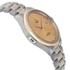 An image of a wristwatch shown from a side profile view, opposite the crown. The watch is unworn and features a dual-tone bracelet with a metallic finish. The face of the watch is angled slightly upward, showcasing its gold-colored dial and date function. The image is taken from a close distance, highlighting the sleek design and craftsmanship.