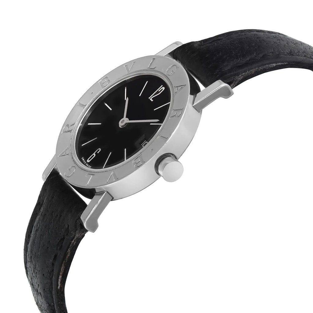 An image of a pre-owned Bvlgari women's wristwatch, featuring a black dial with a date indicator. The watch is positioned at a slight angle, showcasing its sleek steel bezel engraved with the brand name. The timepiece is shot from a close distance, highlighting the black leather strap and the side view of the crown.
