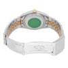 An image of a pre-owned men's Rolex wristwatch, viewed from the back at a slightly elevated angle. The focus is on the closed clasp and the two-tone metal bracelet featuring steel and gold links. The green sticker on the watch case back and the gold winding crown are visible. The image captures the watch from a close distance, highlighting its details and craftsmanship.