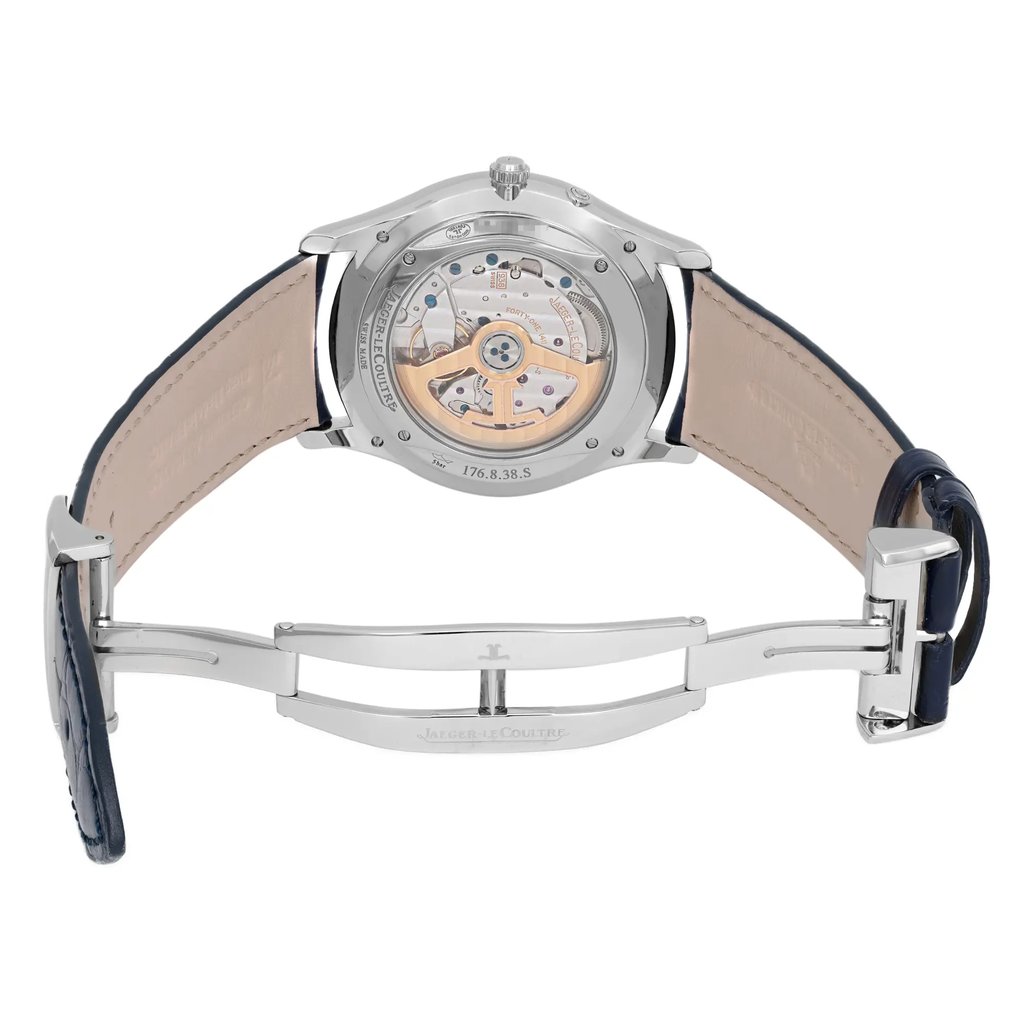 An image of a pre-owned wristwatch viewed from the back, showcasing an open clasp. The watch is positioned centrally, with the back cover facing the viewer. The angle clearly reveals the intricate internal mechanism. The leather strap is spread open, revealing the light-colored inner lining. The image is taken from a medium distance, focusing on the detailed craftsmanship of the watch's back.
