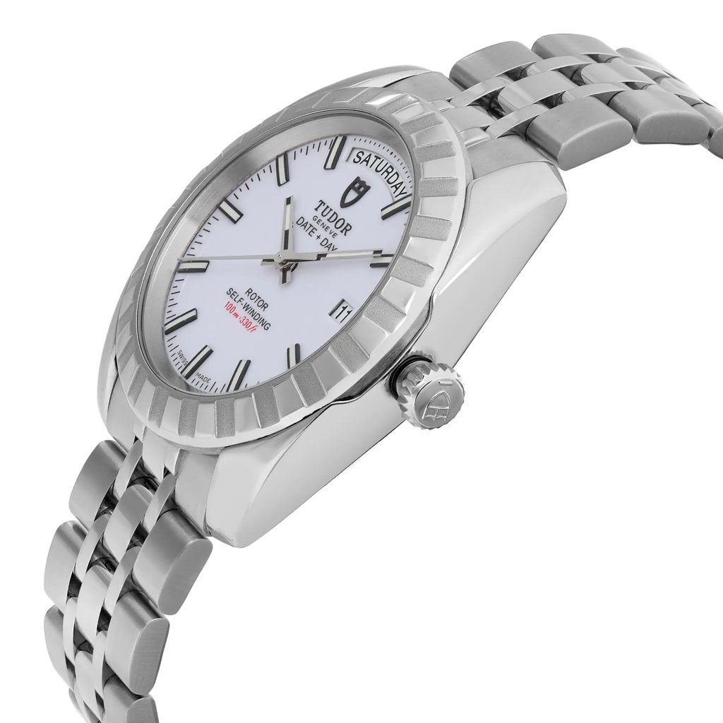 An image of a pre-owned men's TUDOR wristwatch featuring a white dial with day and date displays. The watch is positioned at a slight angle, showcasing the right side and face clearly. The stainless steel bracelet and luminous hands are visible, indicating its sophisticated design. The photograph is taken from a close distance, highlighting the intricate details of the watch's bezel and crown.
