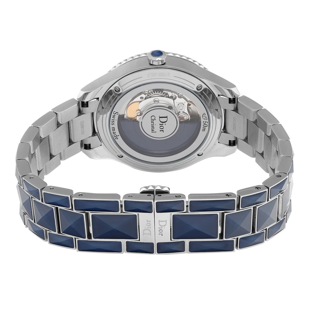 An image of a wristwatch showing the back view with a focus on the open clasp. The watch features a metallic band with blue, rectangular accents. The transparent case back reveals the inner mechanisms, and the brand name is visible. The image is taken at a close distance, highlighting the intricate details of the watch's design and craftsmanship.