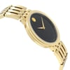 An image of a wristwatch shown from the side profile view, opposite the crown. The watch features a gold-toned case and bracelet with a black dial. The timepiece is positioned at a slight angle, highlighting its sleek design. The condition is noted as new with defects.